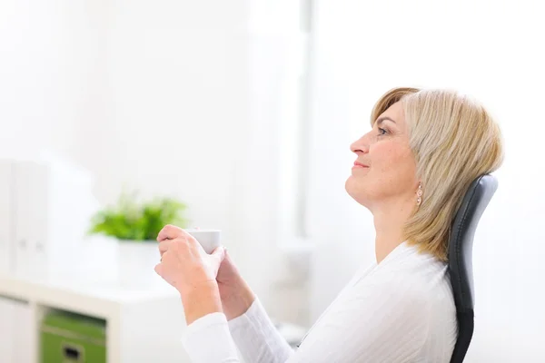 Portret van dromen senior zakenvrouw met kop koffie — Stockfoto