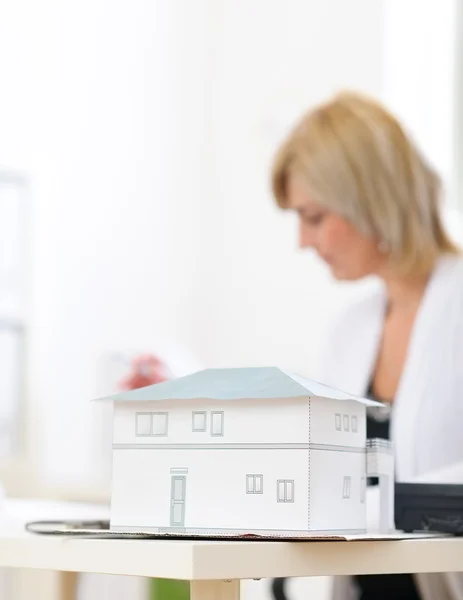 Close-up em escala modelo de casa e mulher arquiteto em backgroun — Fotografia de Stock