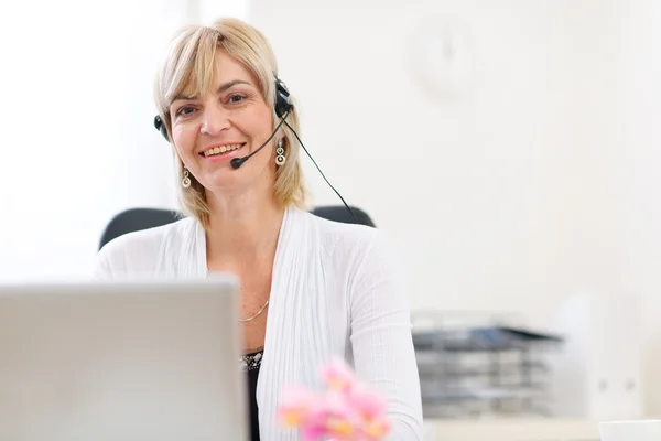 Szczęśliwy senior biznesmenka z zestawem słuchawkowym działa na laptopie — Zdjęcie stockowe