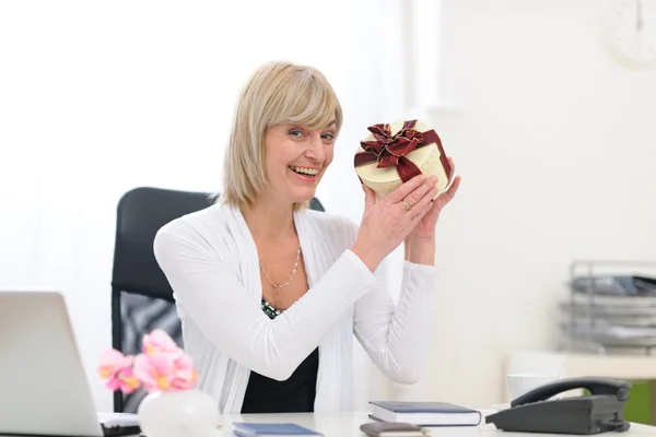 Mutlu bir üst düzey iş kadını ofiste hediyesi var — Stok fotoğraf