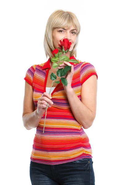 Glad medelålders kvinna att lukta röd ros — Stockfoto