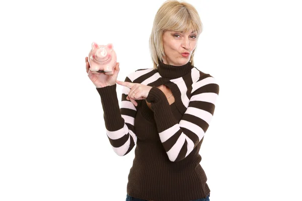 Happy middle age woman pointing on piggy bank — Stock Photo, Image