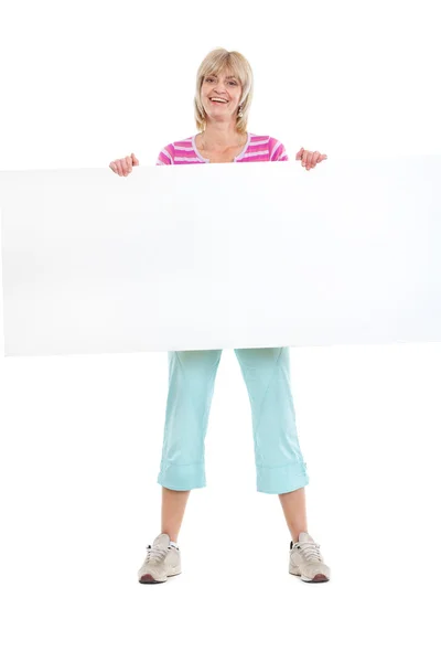 Full length portrait of smiling middle age woman holding blank b — Stock Photo, Image