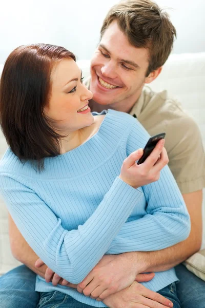 Mooi meisje iets in mobiele telefoon tonen aan vriendje — Stockfoto