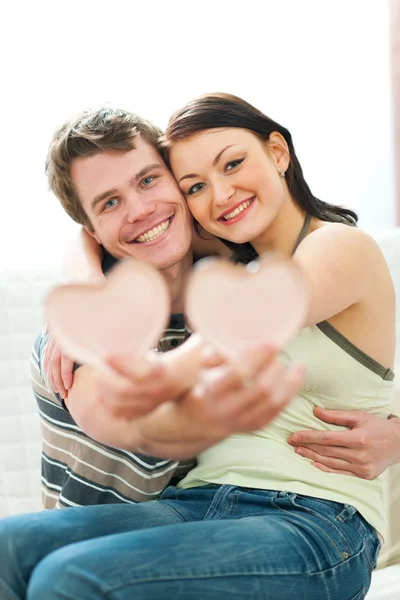 Portrait of happy young couple with porcelain hearts — Stock Photo, Image