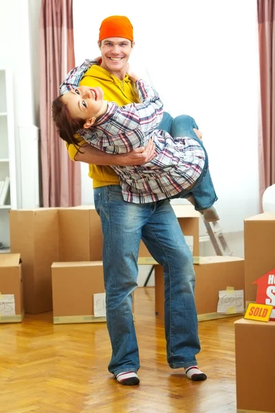 Young couple having fun while moving to new house — Stock Photo, Image