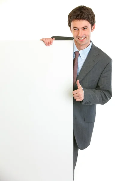 Modern businessman showing blank billboard and thumbs up gesture — Stock Photo, Image