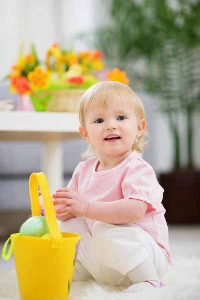 Baby gathering Easter eggs in basket — Stock Photo, Image