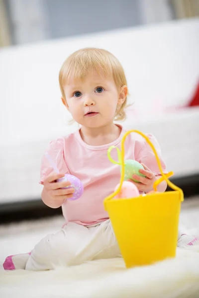 Kid gathering Easter eggs in basket — Stock Photo, Image