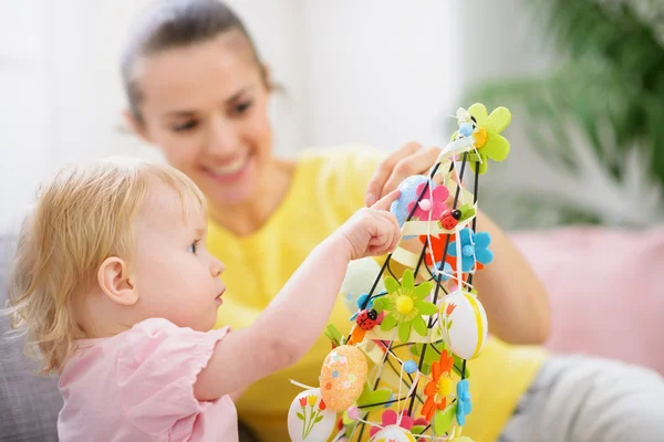 Mother helping baby made Easter decoration — Stock Photo, Image