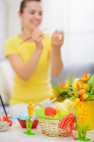 Корзина с пасхальными яйцами и рисунок на яйцеклетке женщины на заднем плане — стоковое фото