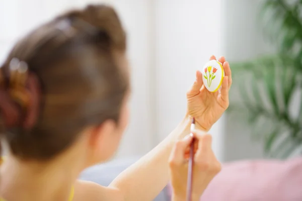 Woman painting pattern on Easter egg — Stock Photo, Image