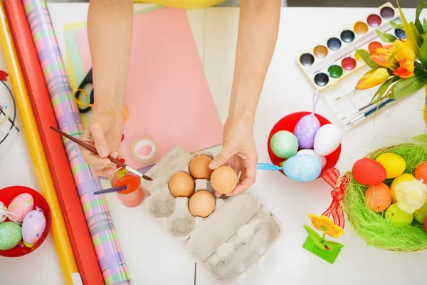 Preparativos para a Páscoa. Fechar as mãos pintando no ovo . — Fotografia de Stock