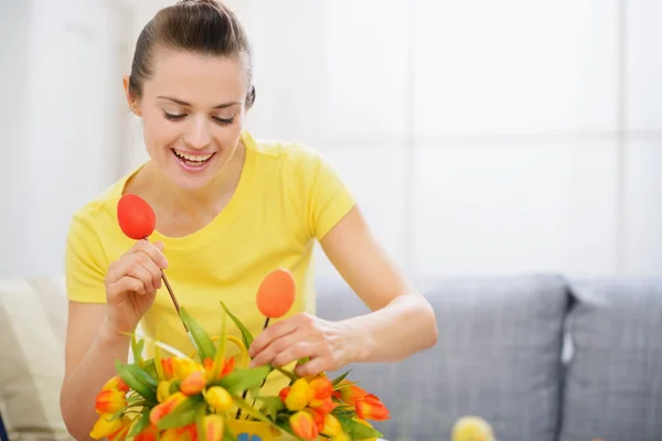 Gelukkig huisvrouw versieren boeket van bloemen voor Pasen — Stockfoto
