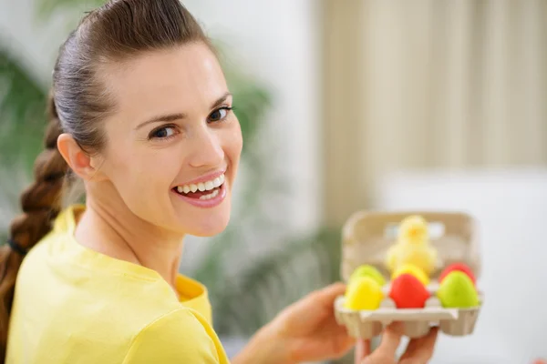 Mulher feliz segurando bandeja com ovos de Páscoa coloridos — Fotografia de Stock