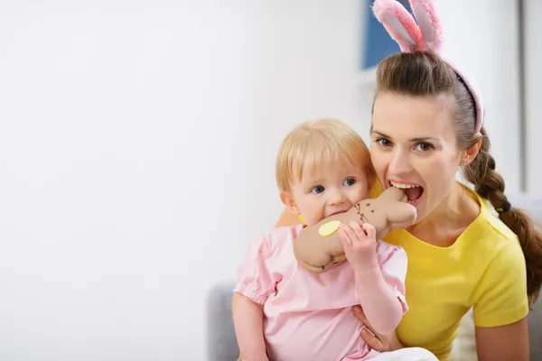 Мама и ребенок кусают шоколадное печенье пасхального кролика — стоковое фото