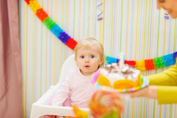 Mutter trägt Kuchen für überraschtes Baby — Stockfoto