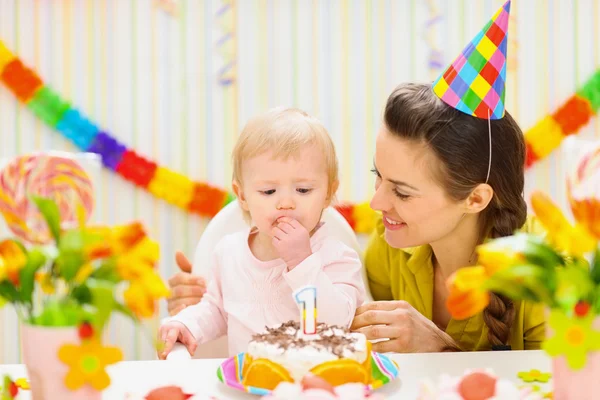 Portrait of happy mom and baby eating birthday cake — Stock Photo, Image