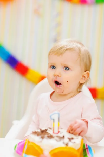 Surprised baby eating first birthday cake — Stock Photo, Image