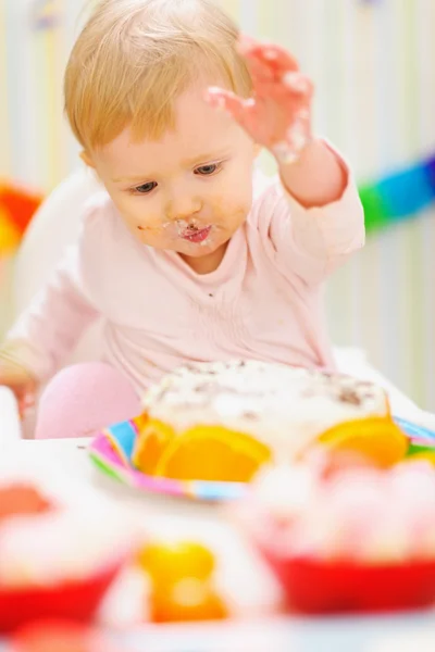 Eten vlekkerig baby met plezier met cake van de kindverjaardag — Stockfoto