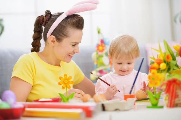 Madre y bebé pintando en huevos de Pascua Imágenes De Stock Sin Royalties Gratis