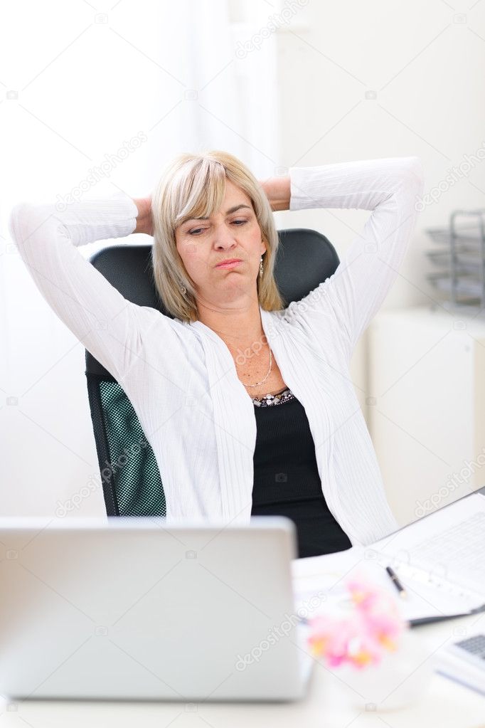 Tired senior business woman looking on computer
