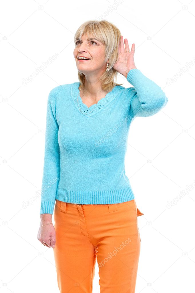 Middle age woman holding hand near ear and trying to hear someth