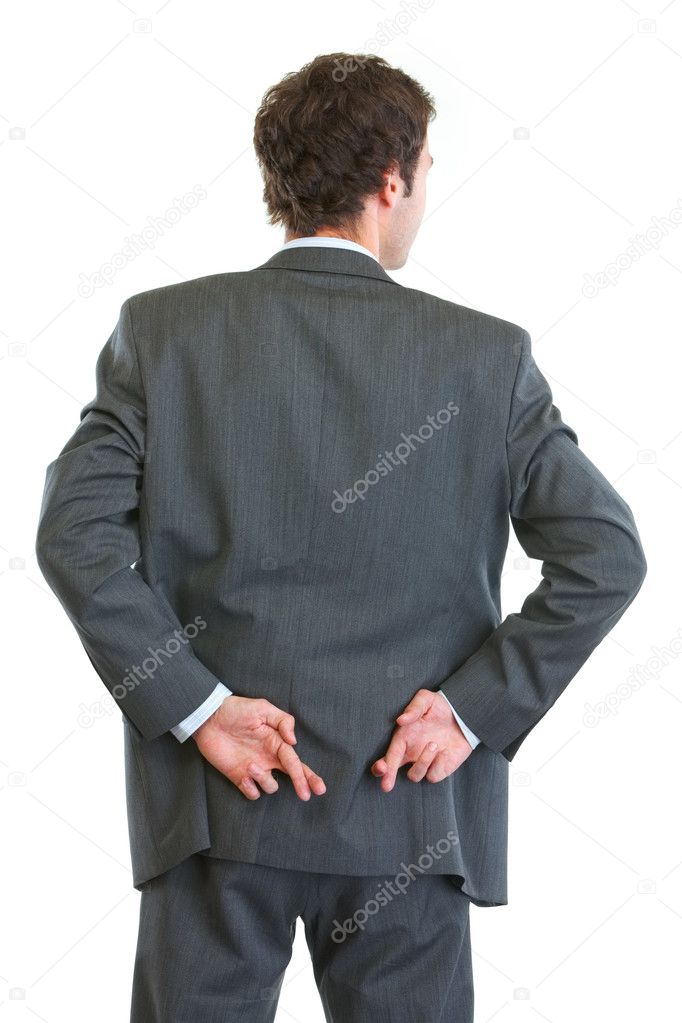 Business man standing back to camera with crossed fingers