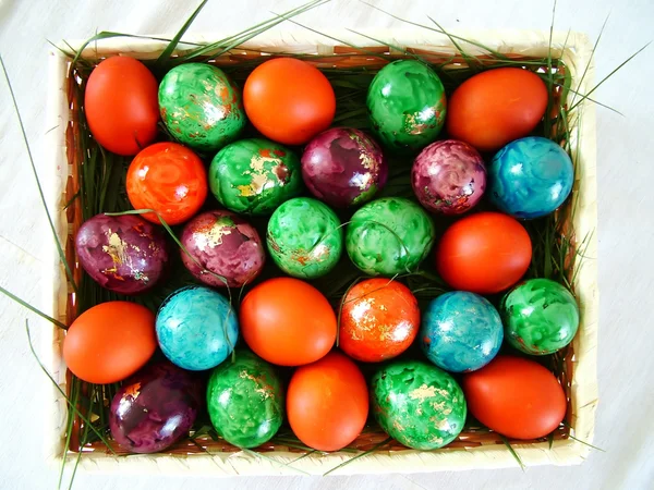 Easter colored eggs layed on grass in a basket Royalty Free Stock Images