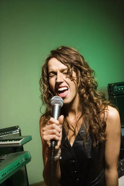 Kobieta śpiewa do mikrofonu. — Zdjęcie stockowe