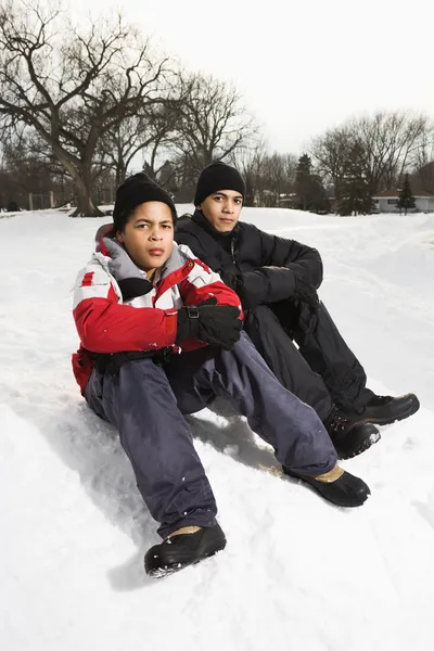 Pojkar sitter i snö. — Stockfoto