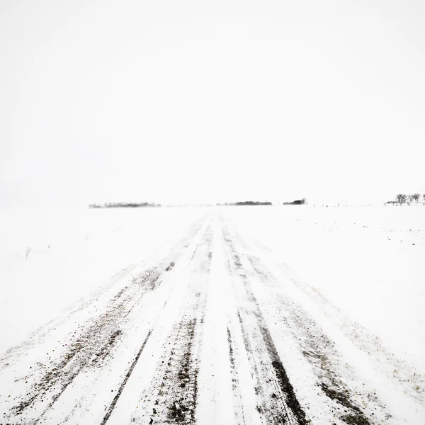 Onverharde weg in winter storm. — Stockfoto