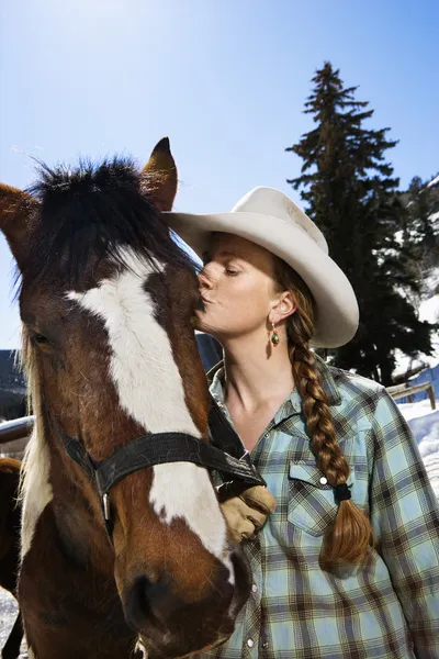 Привлекательная молодая женщина, целующая лошадь — стоковое фото