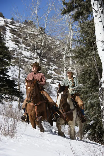Uomo e donna a cavallo nella neve — Foto Stock