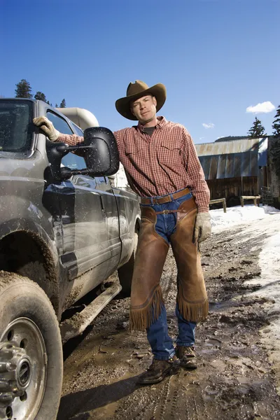 Man klädd i cowboyhatt stående bredvid lastbil — Stockfoto