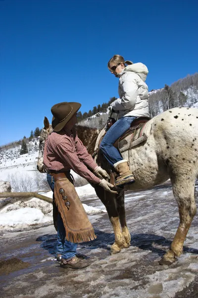 Wrangler helping with horse. — Stock Photo, Image