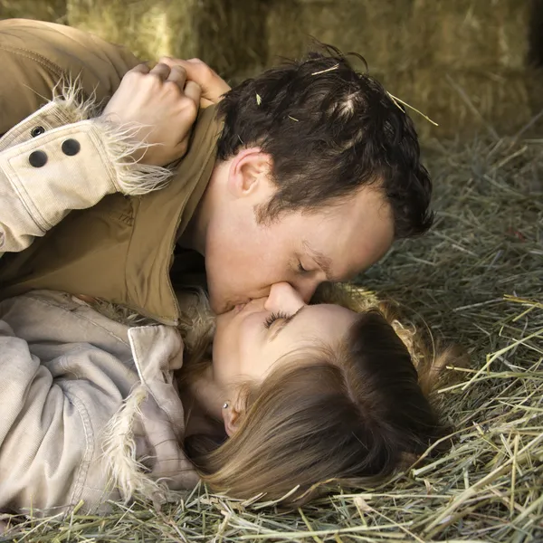 Kissing couple in hay. — Stock Photo, Image