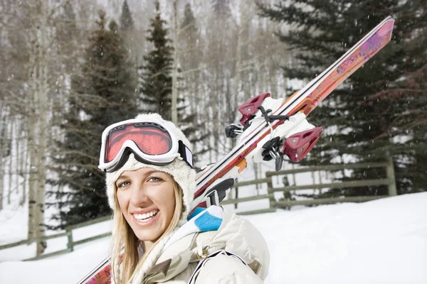 Улыбающаяся женщина с лыжами . — стоковое фото