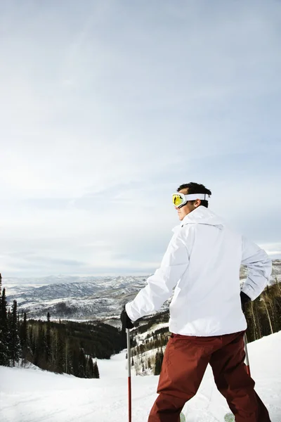 Skiër op berg met uitzicht op vallei — Stockfoto