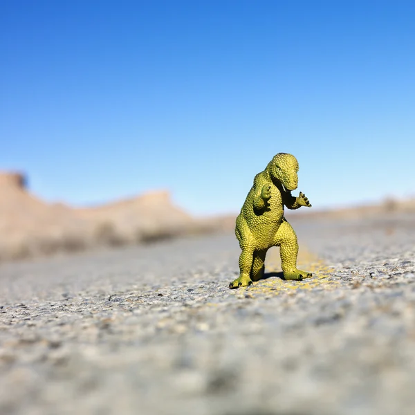 Dinossauro brinquedo na estrada . — Fotografia de Stock