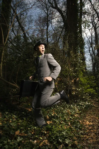 Молодой бизнесмен, бегущий в лесу — стоковое фото