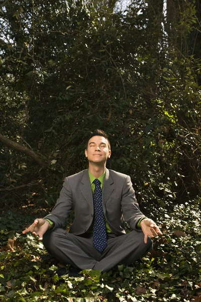 Молодой бизнесмен, сидящий в медитации — стоковое фото