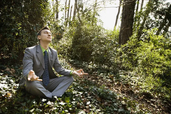 Jovem empresário sentado em meditação — Fotografia de Stock
