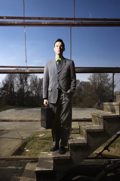 Молодой бизнесмен, стоящий на лестнице — стоковое фото