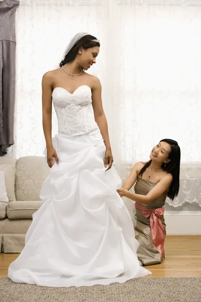 Dama de honor ajustando el vestido de novia . — Foto de Stock