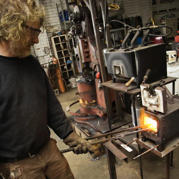 Metalsmith heating metal in forge. — Stock Photo, Image