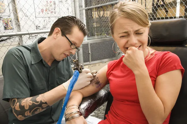 Man tattooing woman. — Stock Photo, Image