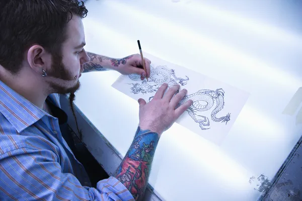Hombre diseñando tatuaje . —  Fotos de Stock