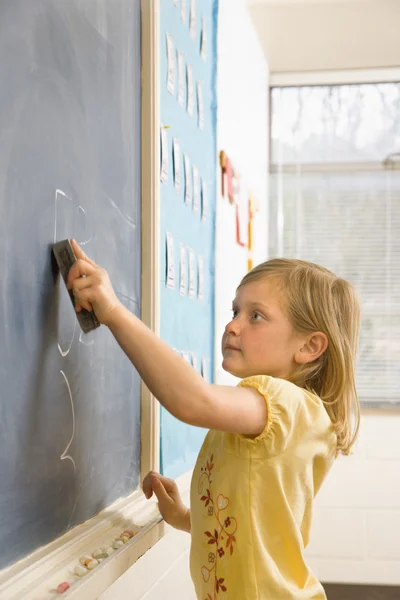 Girl Erasing Writing on Blackboard — Zdjęcie stockowe