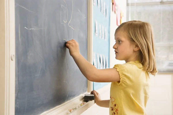 Menina fazendo matemática no quadro negro — Fotografia de Stock